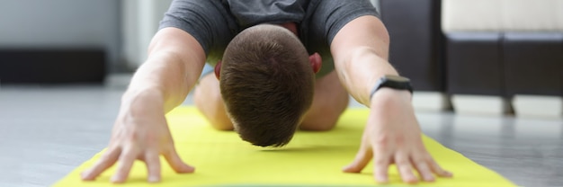 Le jeune homme fait des exercices pour étirer ses muscles du dos