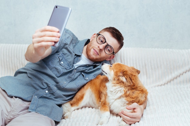 Un jeune homme fait un selfie avec un chien sur son mobile. Blog conceptuel