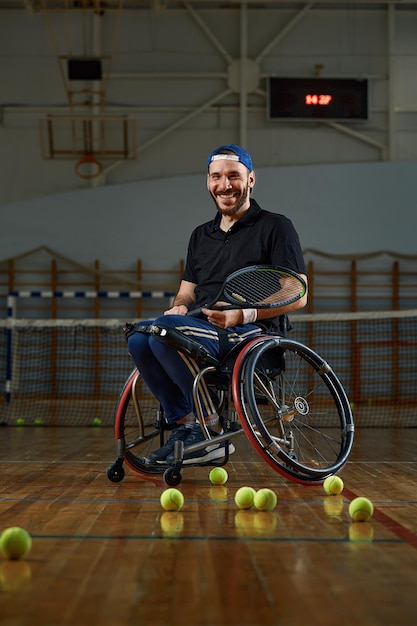 Jeune homme en fauteuil roulant jouant au tennis sur cour