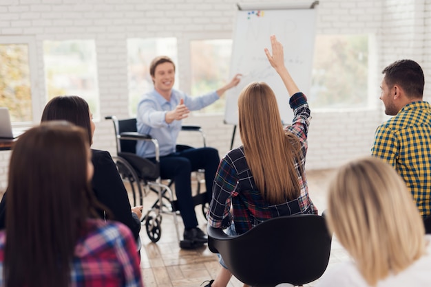 Jeune homme en fauteuil roulant se dirige vers le tableau à feuilles mobiles