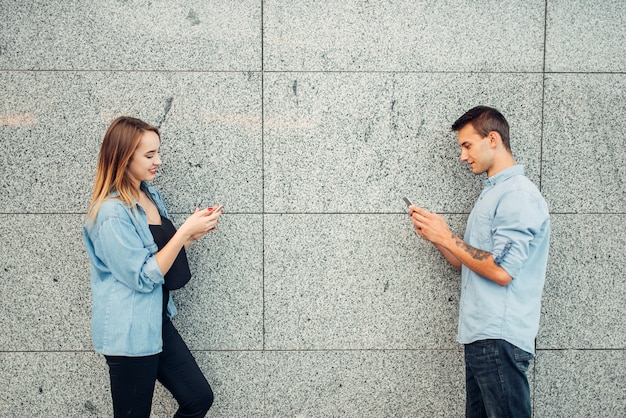 Photo jeune homme et femme accro au téléphone, problème de dépendance, toxicomanes sociaux, mode de vie moderne