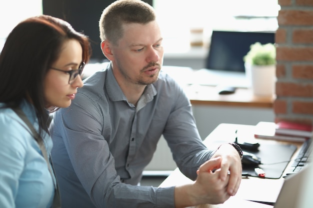 Jeune homme et femme assis au bureau au bureau