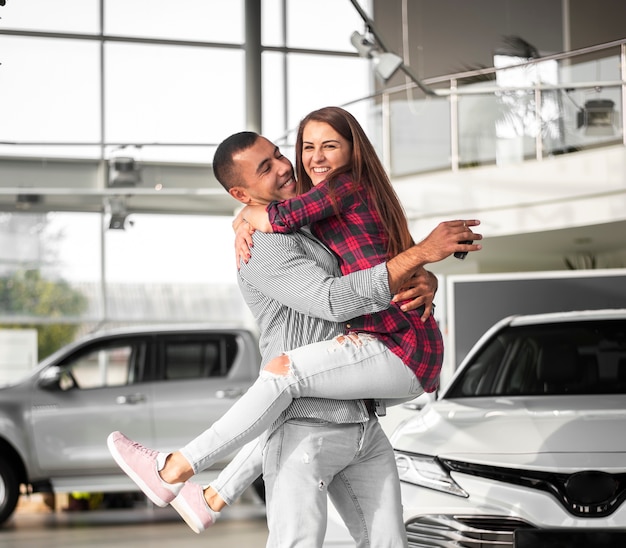 Photo jeune homme et une femme célèbrent une nouvelle voiture