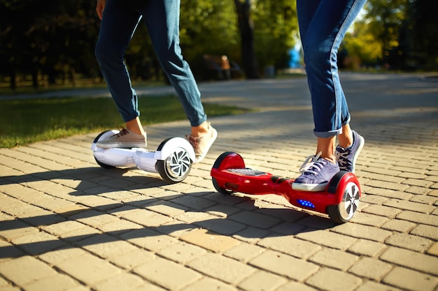 Jeune homme et femme à cheval sur le Hoverboard dans les technologies de contenu du parc un nouveau mouvement