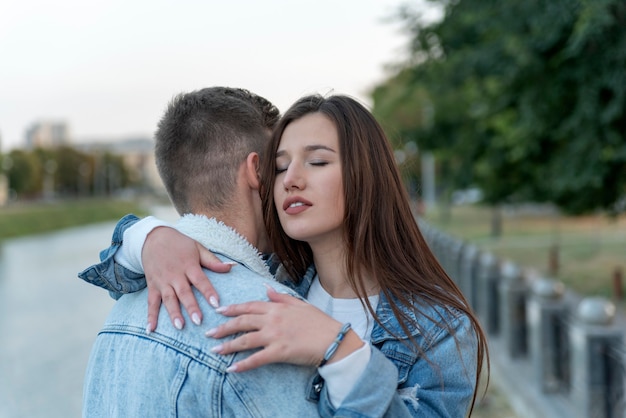 Jeune homme et femme embrassent en plein air. Portrait de jeune couple. Doux câlins sur fond de ville. Un rendez-vous romantique.