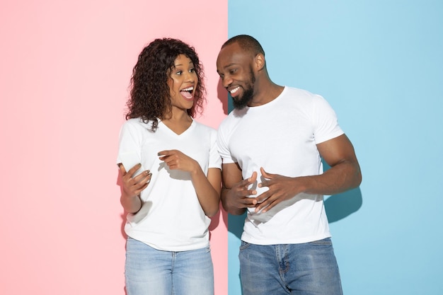 Jeune homme et femme émotifs sur le fond rose et bleu