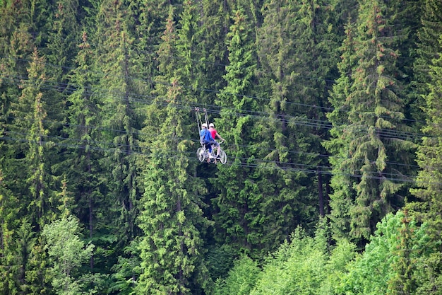 Un jeune homme et une femme font du vélo spécial glissant sur des cordes au-dessus du sol