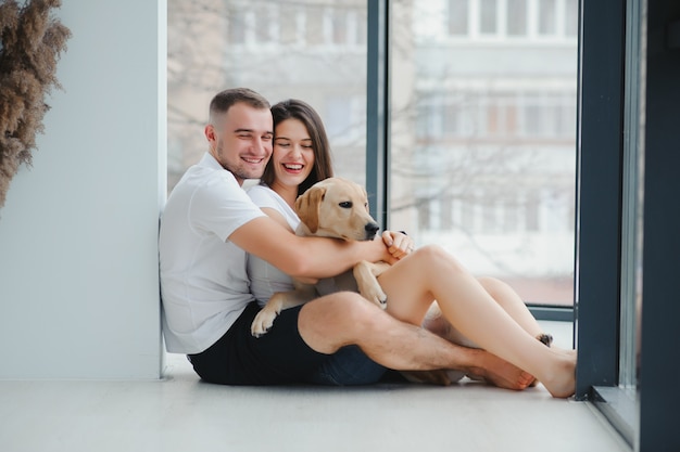 Jeune homme et une femme jouant à la maison avec un chien