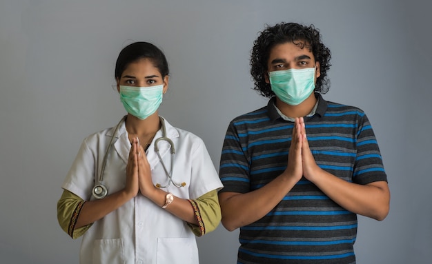 Jeune homme et femme médecin faisant Namaste à cause de l'épidémie de COVID-19. Nouveau message d'accueil pour éviter la propagation du coronavirus au lieu de le saluer avec un câlin ou une poignée de main. Pratique du yoga pour l'équilibre mental.