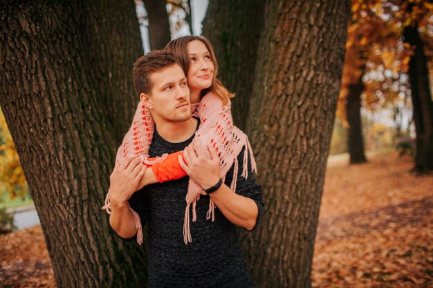 Jeune homme et femme regardent dans une direction et s'embrassent