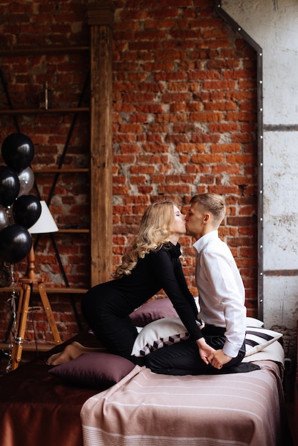 Un jeune homme et une femme s'embrassent dans un intérieur de style loft