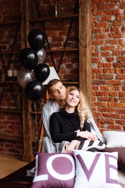 Un jeune homme et une femme s'embrassent dans un intérieur de style loft