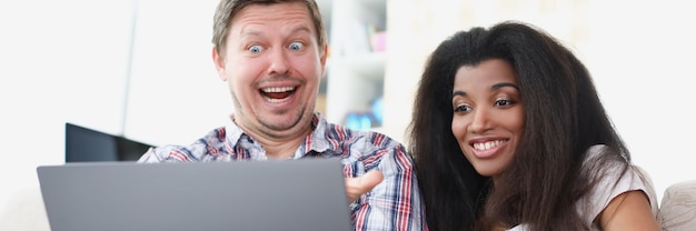 Photo jeune homme et femme sont assis devant un écran d'ordinateur portable et sourient