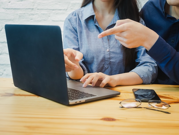 Jeune homme et femme travaillant au bureau. Femme d&#39;affaires pointant sur l&#39;ordinateur portable.