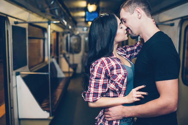 Photo jeune homme et femme utilisent le métro. couple dans le métro. baiser romantique.