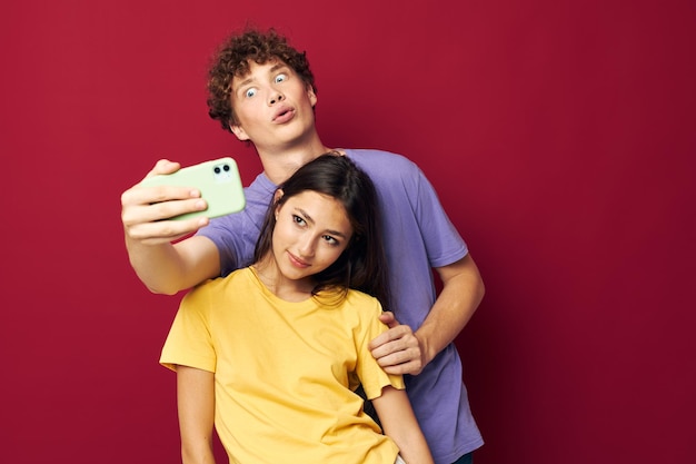 Jeune homme et fille prennent un selfie posant câlin fond isolé