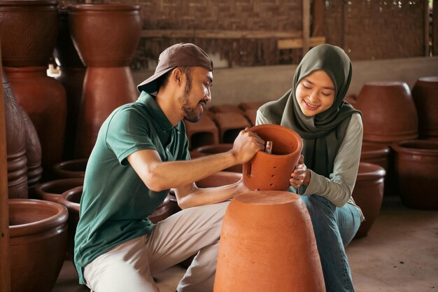 Jeune homme et fille voilée regardant la poterie