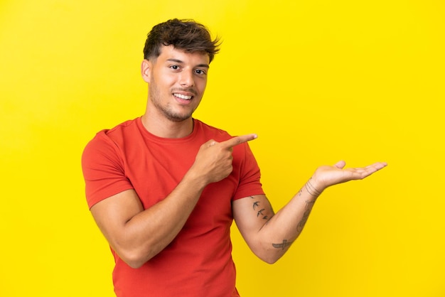 Jeune homme sur fond bleu et vert faisant un geste de klaxon