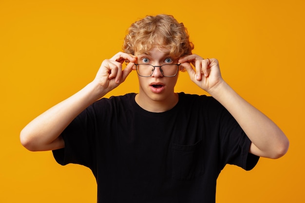 Jeune homme sur fond jaune avec une expression faciale de surprise