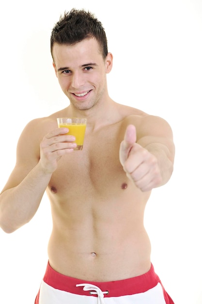 Jeune homme en forme pressant du jus d'orange isolé sur blanc