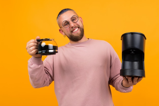 Un jeune homme fort est titulaire d'une cafetière