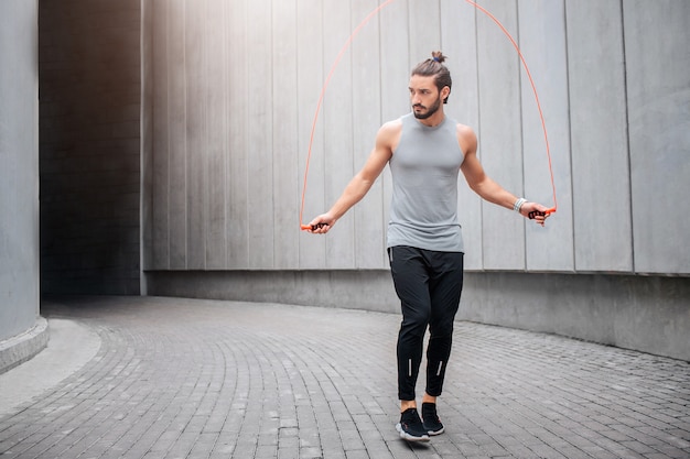 Jeune homme fort et musclé sautant une corde