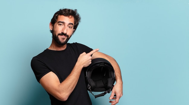 Jeune homme fou barbu avec un casque de moto