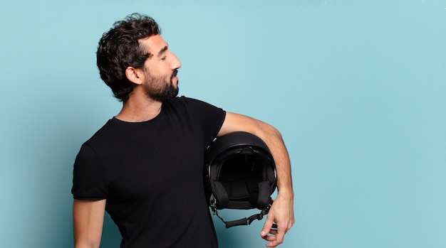 Jeune homme fou barbu avec un casque de moto