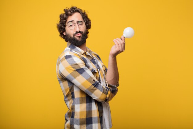 Jeune homme fou fou imbécile pose avec une ampoule. idée ou inspiration