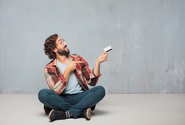 Jeune homme fou fou imbécile pose avec une carte de crédit. argent ou argent