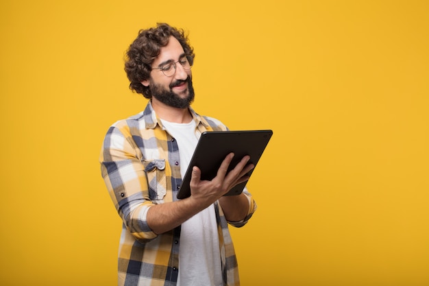 Jeune homme fou fou imbécile pose avec un écran tactile tablette intelligente