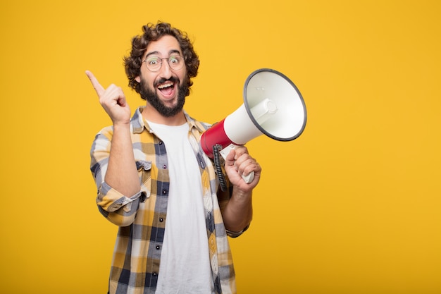 Jeune homme fou fou imbécile pose avec un mégaphone. annonce co