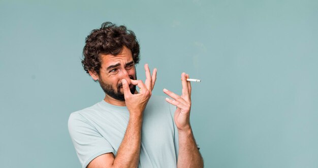 Jeune homme fou hispanique adulte avec une cigarette