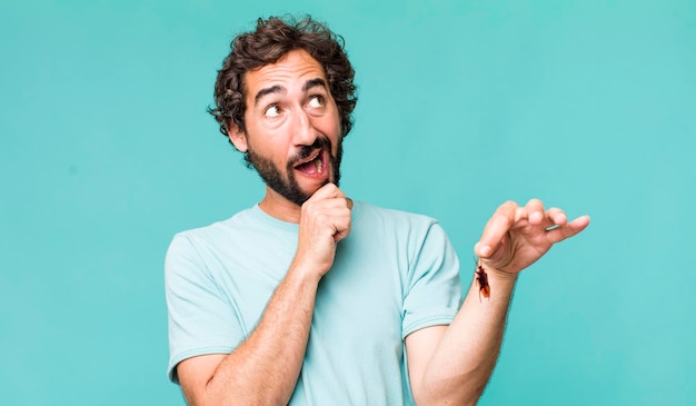 Photo jeune homme fou hispanique adulte avec un insecte cafard