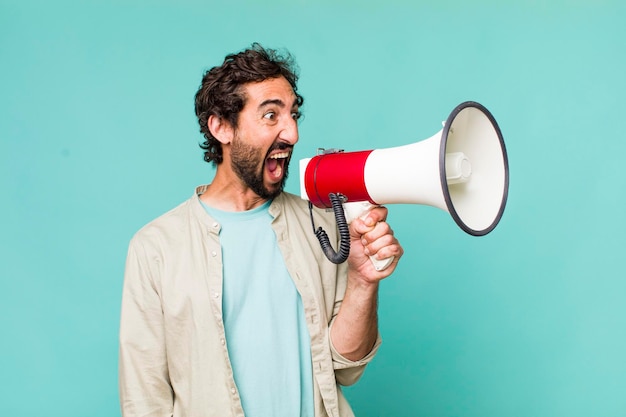 Jeune homme fou hispanique adulte avec un mégaphone