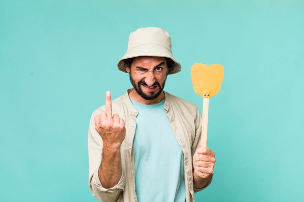 Jeune homme fou hispanique adulte avec une tapette à mouche