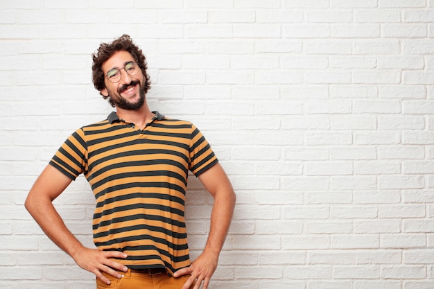 Jeune homme fou ou idiot, gesticulant et exprimant des émotions sur fond de mur de briques