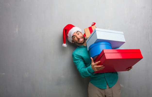 Photo jeune homme fou tenant des cadeaux pour célébrer noël