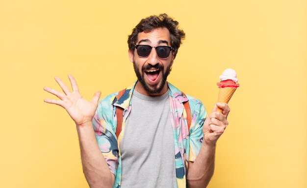 Jeune homme fou de voyageur surpris expression et tenant une glace