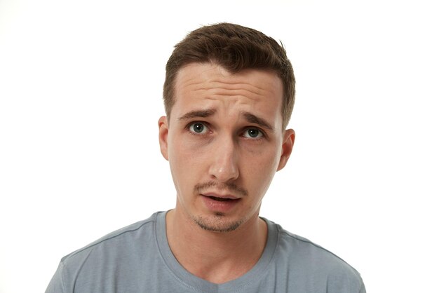 Photo un jeune homme frustré sur un fond blanc de tristesse.