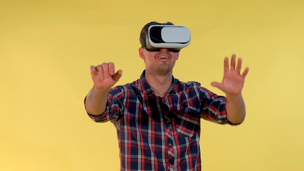 Photo un jeune homme gai est étonné d'utiliser des lunettes vr il y a un fond jaune