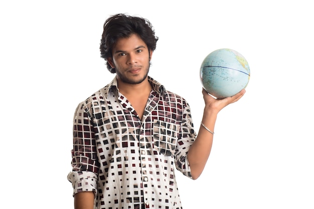 Jeune homme avec un globe terrestre sur un blanc.