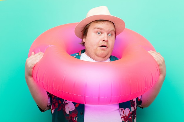 Jeune homme de grande taille avec un beignet gonflable