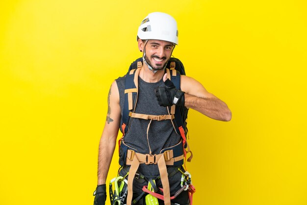 Jeune homme grimpeur caucasien isolé sur fond jaune donnant un geste du pouce levé