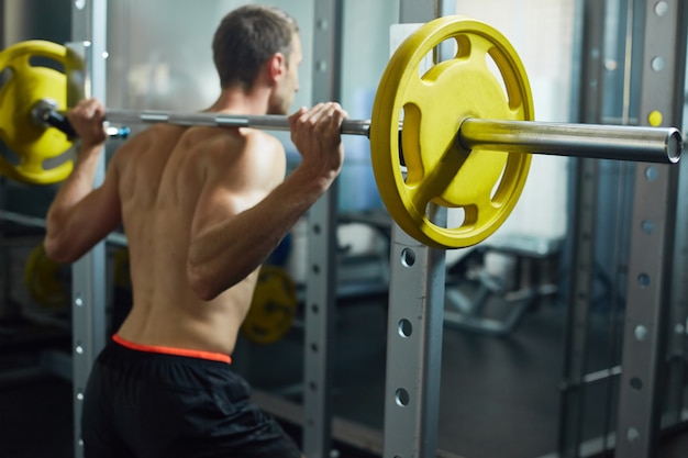 Jeune homme haltérophilie dans la salle de gym