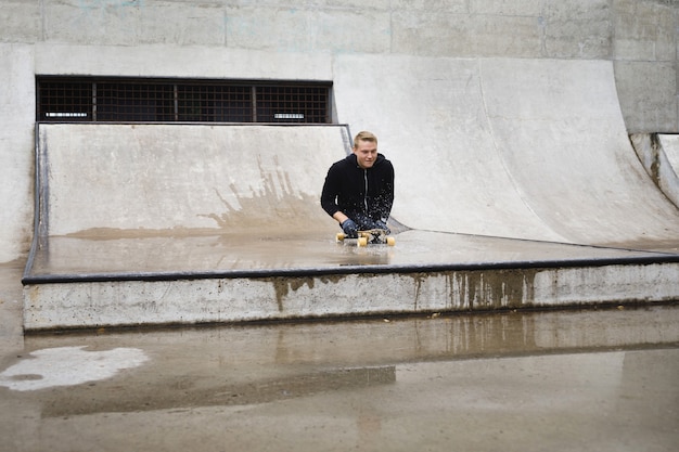 Jeune homme handicapé et motivé avec un longboard dans le skatepark