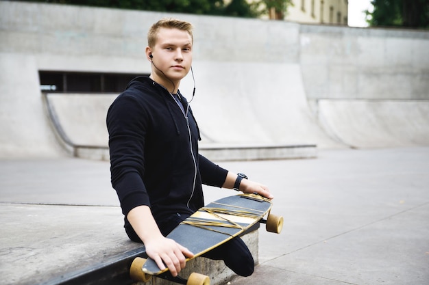 Jeune homme handicapé motivé avec un longboard dans un skatepark