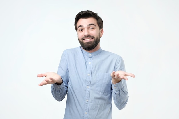 Jeune homme haussant les épaules en disant qui s'en soucie alors ce que je ne sais pas geste