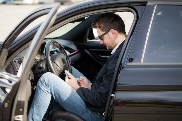 Jeune homme heureux a acheté une nouvelle voiture moderne.