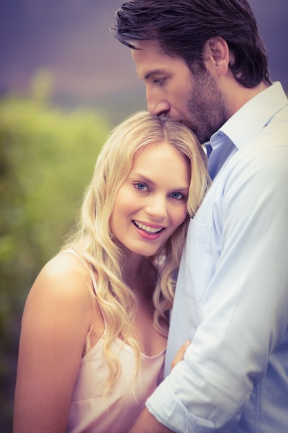 Jeune homme heureux embrassant la femme sur le front